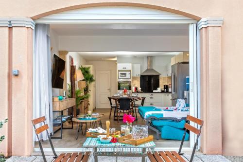 a living room and kitchen with an open patio door at En bord de plage Baie Nettlé, appart 4 couchages tout rénové in Baie Nettle