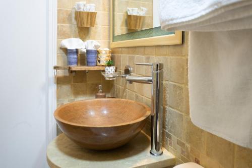 a bathroom with a wooden bowl sink on the wall at En bord de plage Baie Nettlé, appart 4 couchages tout rénové in Baie Nettle
