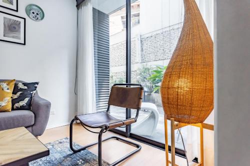 a rattan chair in a living room with a window at San Carlos rentals - Lastarria in Santiago