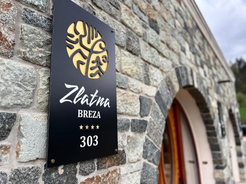 a sign on the side of a brick building at Toplik Village Resort in Lukavica