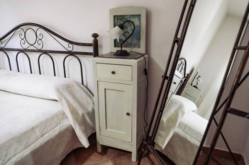 a bedroom with a white bed and a mirror at Villa Kalorama-private pool & Hot Tub in San Vito dei Normanni