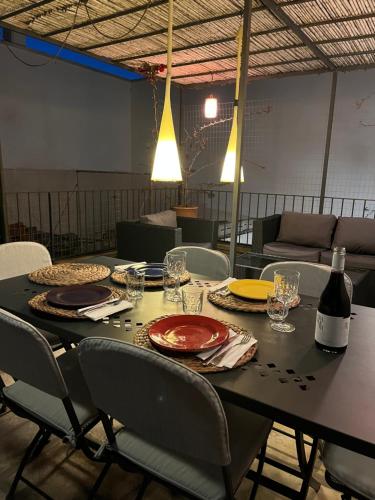 a table with plates and glasses and a bottle of wine at Casa di Nina in Marittima