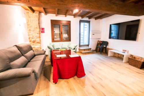 a living room with a couch and a table at Apartamentos A Fala en Trevejo y San Martin de Trevejo, Sierra de Gata in Trevejo