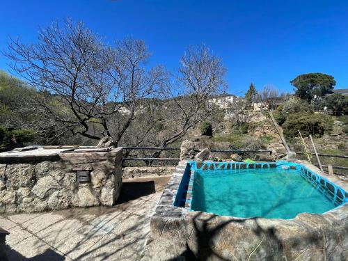 a large swimming pool in a stone building with at Casa Fidelina III Miraflores de la Sierra in Miraflores de la Sierra