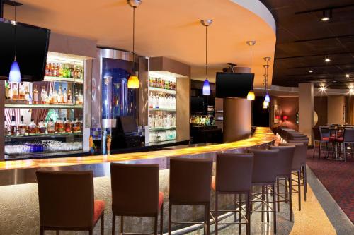 a bar in a hotel with chairs and a bar counter at Courtland Grand Hotel, Trademark Collection by Wyndham former Sheraton Atlanta in Atlanta
