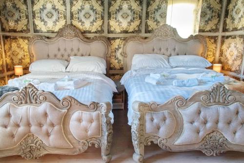 twee bedden naast elkaar in een slaapkamer bij Ultra Deluxe Versace Villa Hot Tub Cinema Room in Saffron Walden