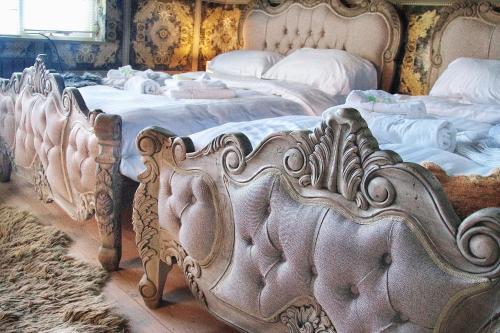 a group of four beds in a room at Deluxe 4 5 Bed Hot Tub Cinema Room 15 in Saffron Walden