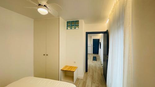 Apartamentos BRAVO MURILLO con garaje en centro histórico في بطليوس: غرفة نوم بسرير وطاولة ومروحة سقف