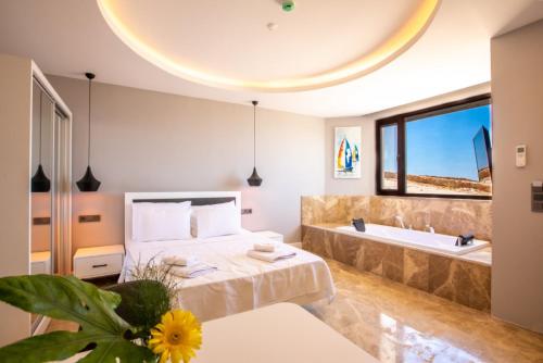 a bedroom with a tub and a bed and a sink at Luxury Flat with Jacuzzi in Kas in Kas
