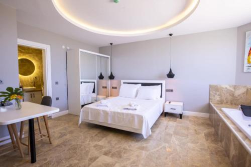 a bedroom with a white bed and a table at Luxury Flat with Jacuzzi in Kas in Kas