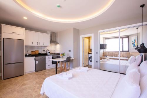 a bedroom with a large bed and a kitchen at Luxury Flat with Jacuzzi in Kas in Kas