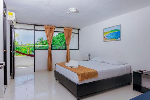 - une chambre avec un lit et une grande fenêtre dans l'établissement Hotel Sol Inn Santa Marta, à Santa Marta