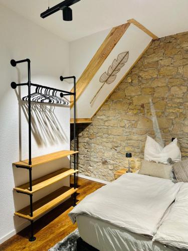 1 dormitorio con cama y pared de piedra en Heimat - Ein Stück Heimat im Alltag, en Bad Dürkheim