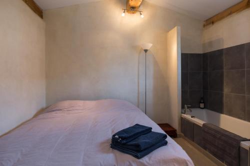 a bedroom with a bed with a blue bag on it at Maison du Manescau in Saint-Pierre-de-Vassols