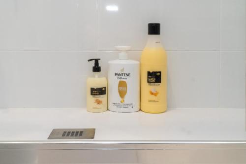 three bottles of laundry detergents sitting on a shelf at B CasaCafé Madrid Pozuelo 2 Baño Fuera de la habitacion o COMPARTIDO in Pozuelo de Alarcón