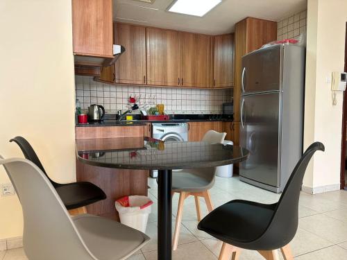 a kitchen with a table and chairs and a refrigerator at The Mood House I Dubai Marina in Dubai
