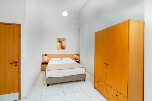 a bedroom with a bed and a wooden cabinet at Emi Seaside in Amoudara Herakliou