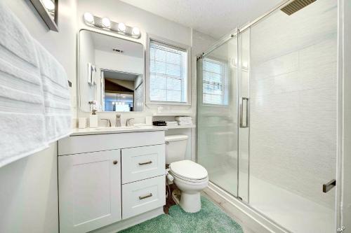 a white bathroom with a toilet and a shower at Lagoon 2623 by Nautical Properties in Panama City Beach