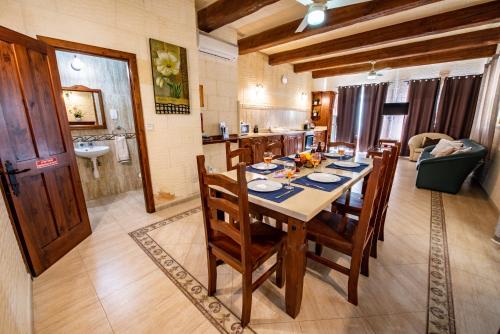 a kitchen and dining room with a table and chairs at Ta Lucija Sleeps 4 with Private Pool in Marsalforn