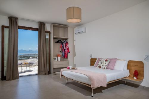 a bedroom with a bed and a large window at Villa Maria con piscina e vista mare in Castellammare del Golfo