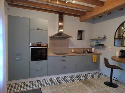 uma cozinha com um lavatório e um fogão forno superior em Moulin de Pisseloube 