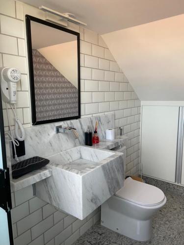 a bathroom with a sink and a toilet at Apart Hotel Seg Total Lofts Encantadores in Mogi-Guaçu