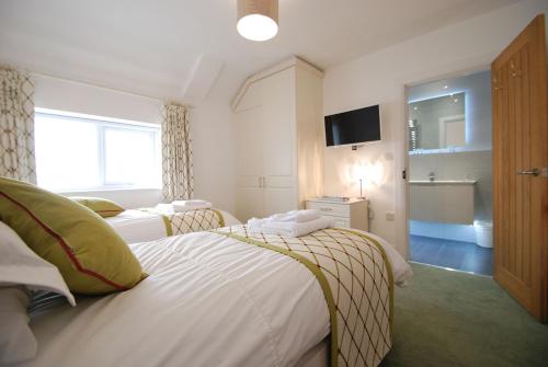 a hotel room with two beds and a television at Waters Edge in Deganwy