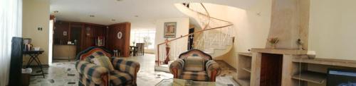 sala de estar con sofá y escalera en Roma Lodges House- Campin Simón Bolivar Movistar Embajada compensar, en Bogotá