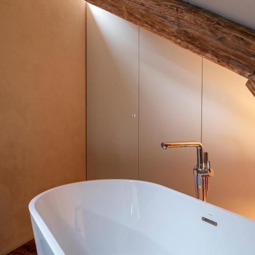 a bath tub with a faucet in a bathroom at GRAACE Suite in Luxembourg