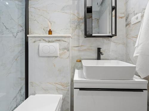 Baño blanco con lavabo y aseo en Luxury Apartment Beyond, en Stobreč