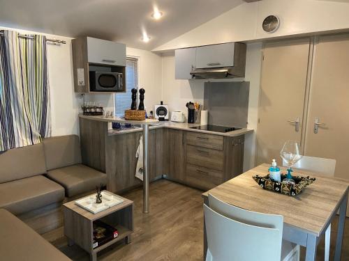 une cuisine et un salon avec un canapé et une table dans l'établissement Mobilhome 516, à La Teste-de-Buch
