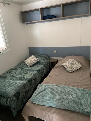 a bedroom with two beds and a window at Mobilhome 516 in La Teste-de-Buch