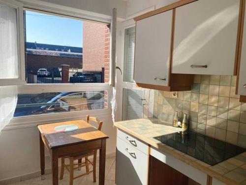 a kitchen with a small table and a window at Appartement spacieux hyper centre ville proximité immédiate Cathédrale, Musée de Picardie, Coliseum in Amiens