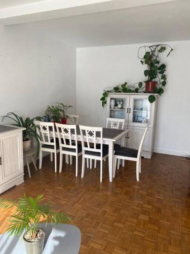 une salle à manger avec une table et des chaises blanches dans l'établissement Appartement spacieux hyper centre ville proximité immédiate Cathédrale, Musée de Picardie, Coliseum, à Amiens