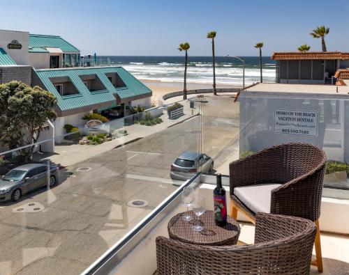 a balcony with a table and chairs and a view of the beach at Sandcastle Hotel on the Beach in Pismo Beach