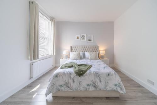 a white bedroom with a bed and a window at Stunning 3 bedroom flat in Southend-on-sea in Southend-on-Sea