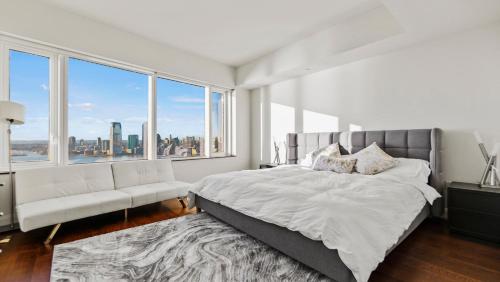 sypialnia z dużym łóżkiem i dużym oknem w obiekcie Luxurious 4 BR Penthouse in NYC w Nowym Jorku