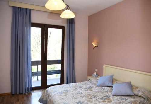 a bedroom with a bed and a large window at Hotel Restaurant Dreri in Tirana