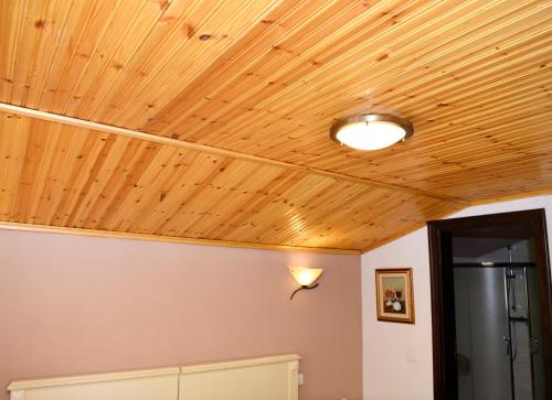 a room with a wooden ceiling with a light on it at Hotel Restaurant Dreri in Tirana