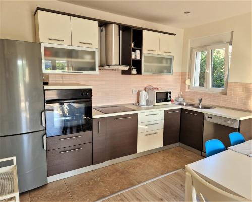 a kitchen with stainless steel appliances and brown cabinets at Villa Petra in Rab