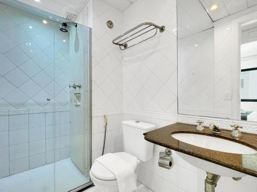 a bathroom with a toilet and a sink and a shower at Lindo Hotel na Paulista in São Paulo