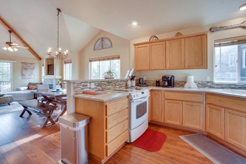 a kitchen with wooden cabinets and a living room at Pet-Friendly Townhome with Hot Tub in Redmond! in Redmond