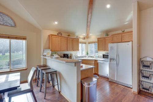 a kitchen with wooden cabinets and a white refrigerator at Pet-Friendly Townhome with Hot Tub in Redmond! in Redmond