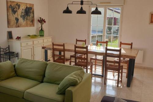 un salon avec un canapé et une table avec des chaises dans l'établissement Le Bellevue à 1 h 30 de Paris et 20 km de Troyes, à Estissac