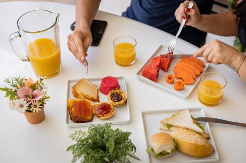 una tavola piena di prodotti per la colazione e succo d'arancia di Valencia Hotel Natal a Natal