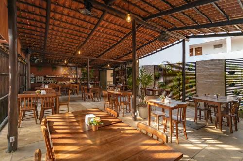 un ristorante con tavoli e sedie in legno e un patio di Valencia Hotel Natal a Natal