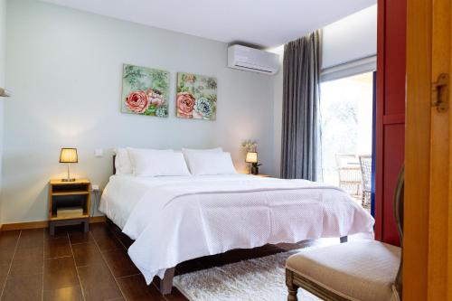 a bedroom with a white bed and a window at Boavista Country Houses no 93 in Vila Nune
