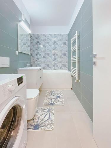 a bathroom with a washer and dryer in it at Pipera onix design in Voluntari