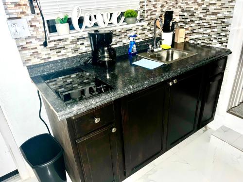 a kitchen counter with a stove and a sink at Miami Gardens Comfort Suite by Hard Rock Stadium in Miami Gardens
