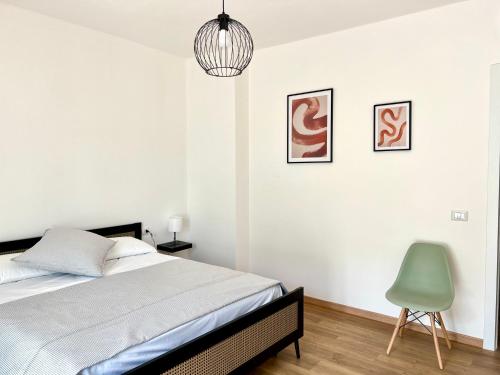 1 dormitorio con 1 cama y 1 silla verde en Cityside apartment, en Selargius